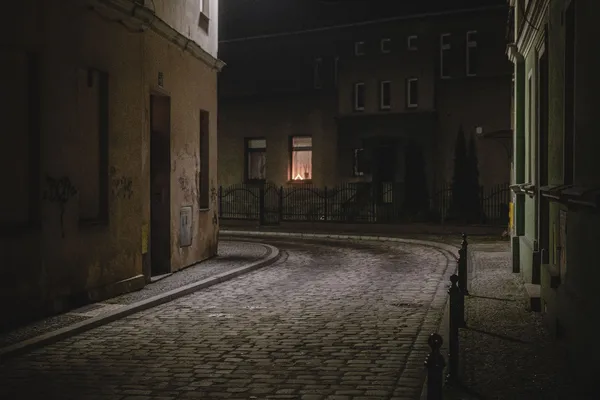 Temná dlážděná ulička v noci