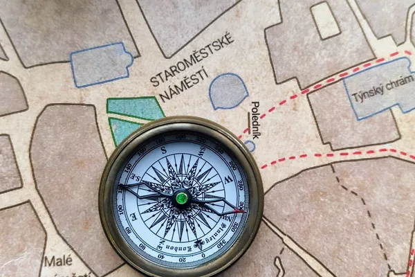 Mosazný kompas na mapě Starého Města