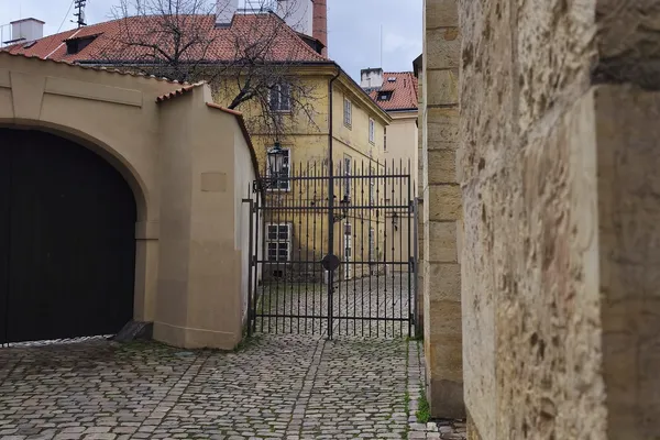Dlážděné nádvoří s kovanou branou