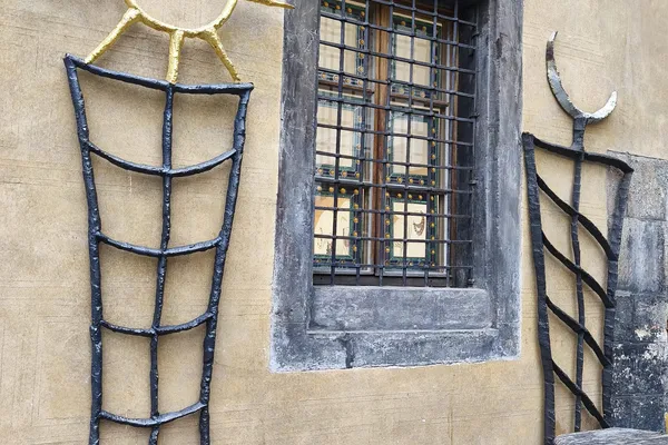 Kované sochy židlí u historického okna